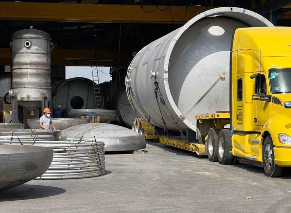 Camión cargado un cilindro metálico sobredimensionado.